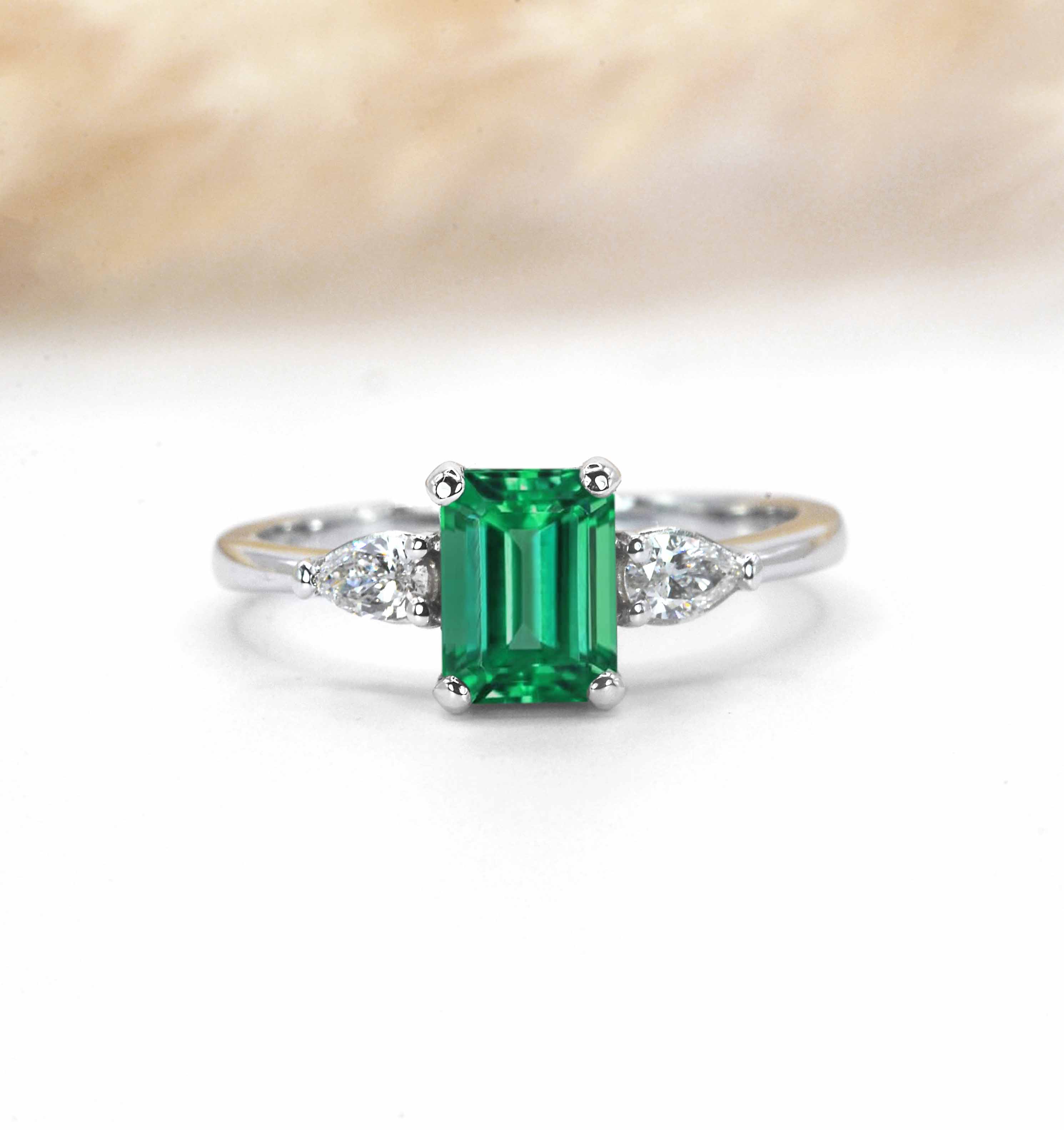 emerald dainty ring with pear diamonds in white gold