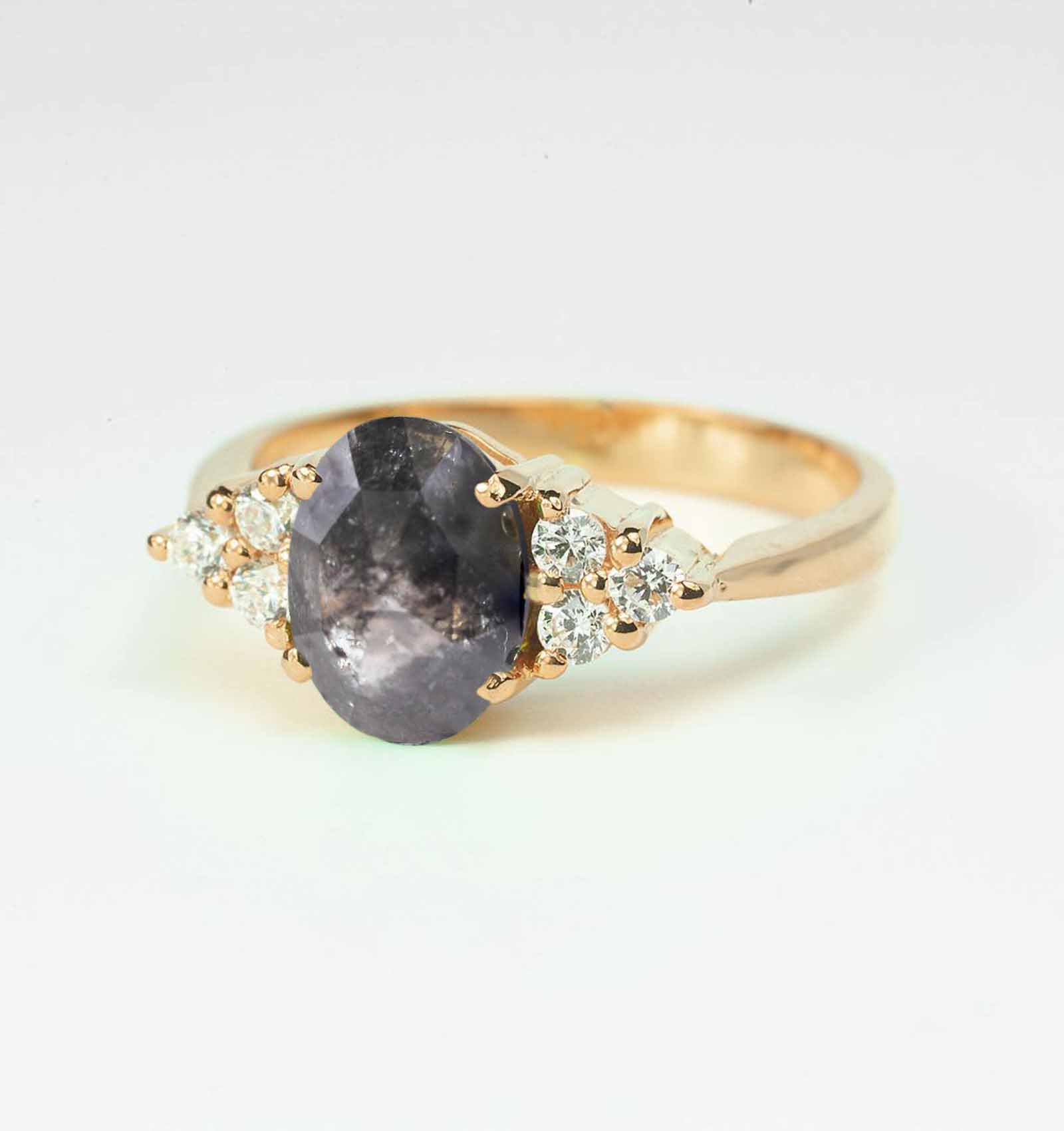 Elegant engagement ring featuring oval salt and pepper diamond and side triplets