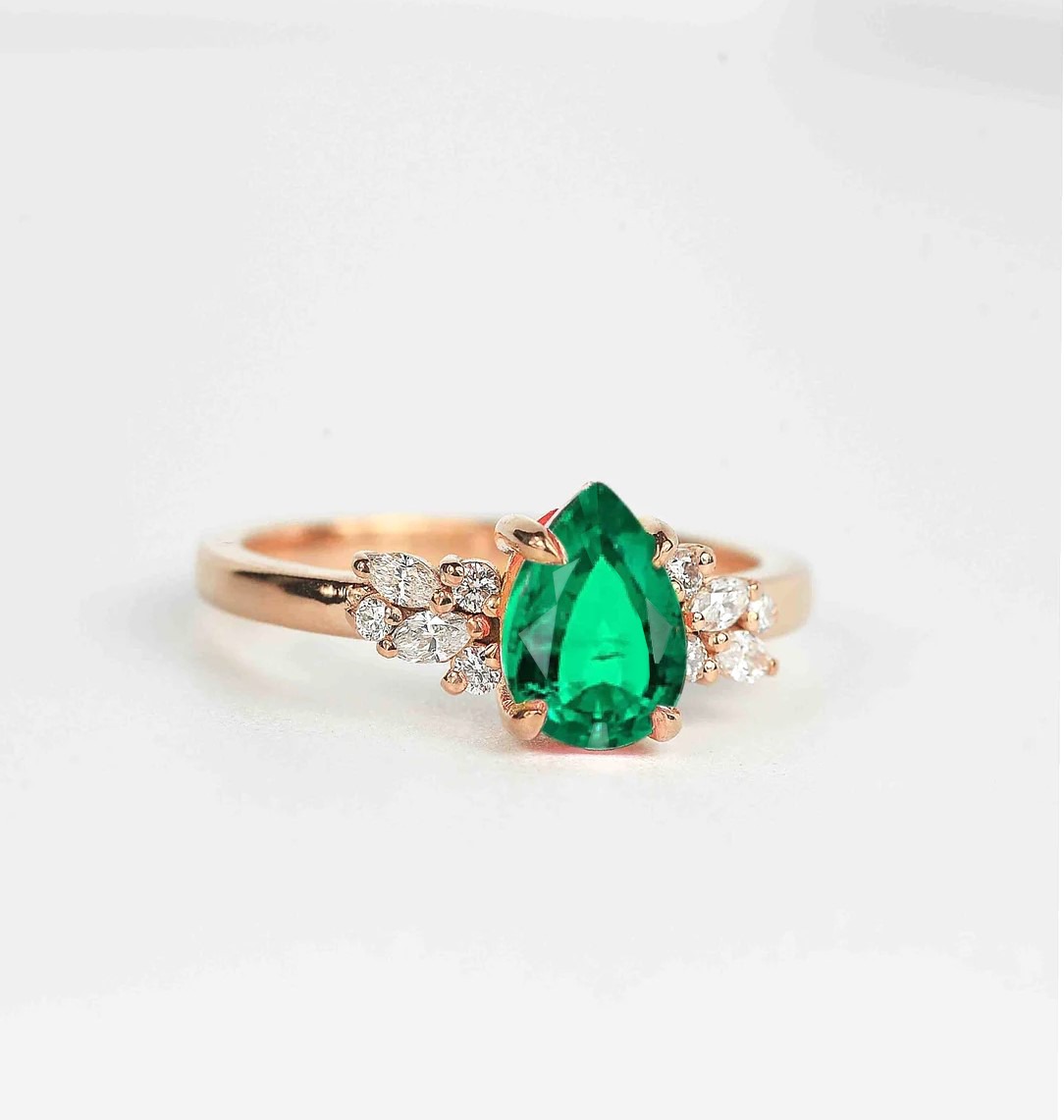 emerald and diamond luxury cluster ring with 8 x 6mm emerald and white accent diamonds. The unique design of this art deco style ring comes with solid 9k,14k or 18k gold or platinum.