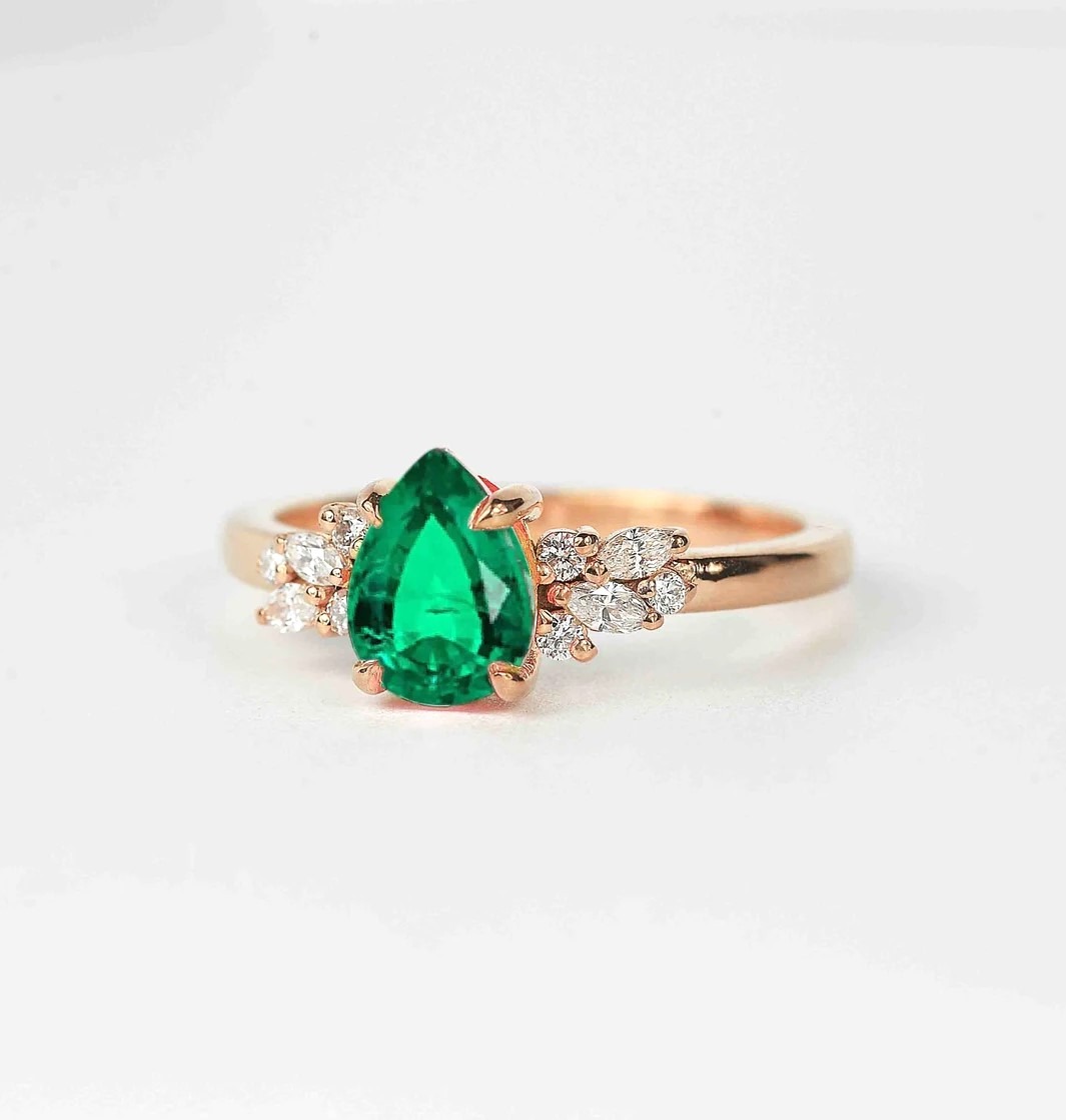 emerald and diamond luxury cluster ring with 8 x 6mm emerald and white accent diamonds. The unique design of this art deco style ring comes with solid 9k,14k or 18k gold or platinum.