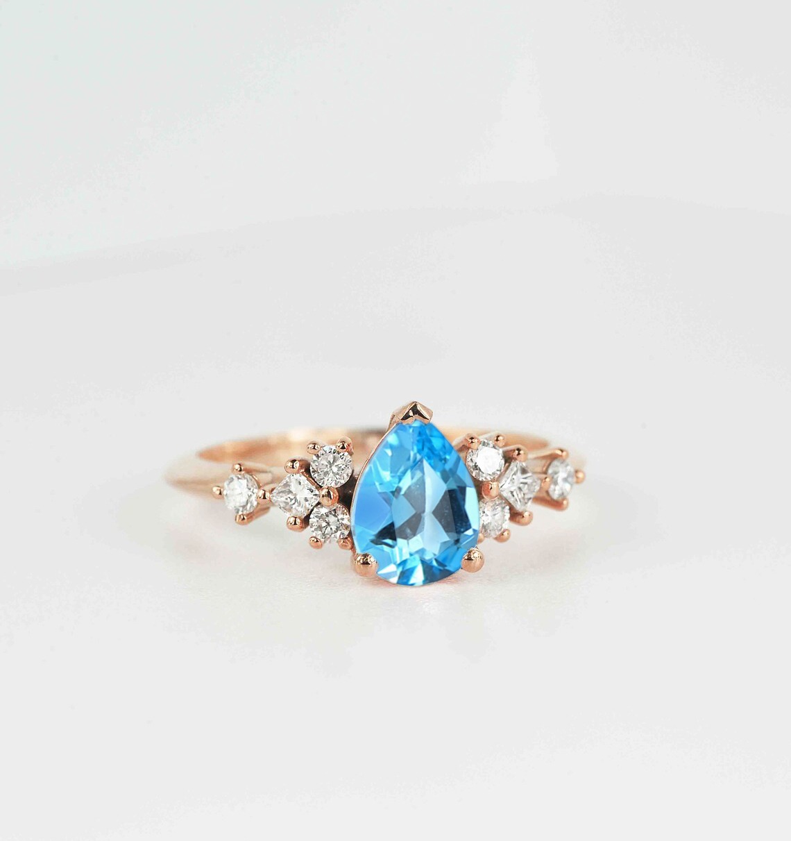 This beautiful pear cut blue topaz bridal ring comes with a center 1.50ct blue topaz and white natural diamonds. Available in rose gold, yellow gold, white gold, or platinum.