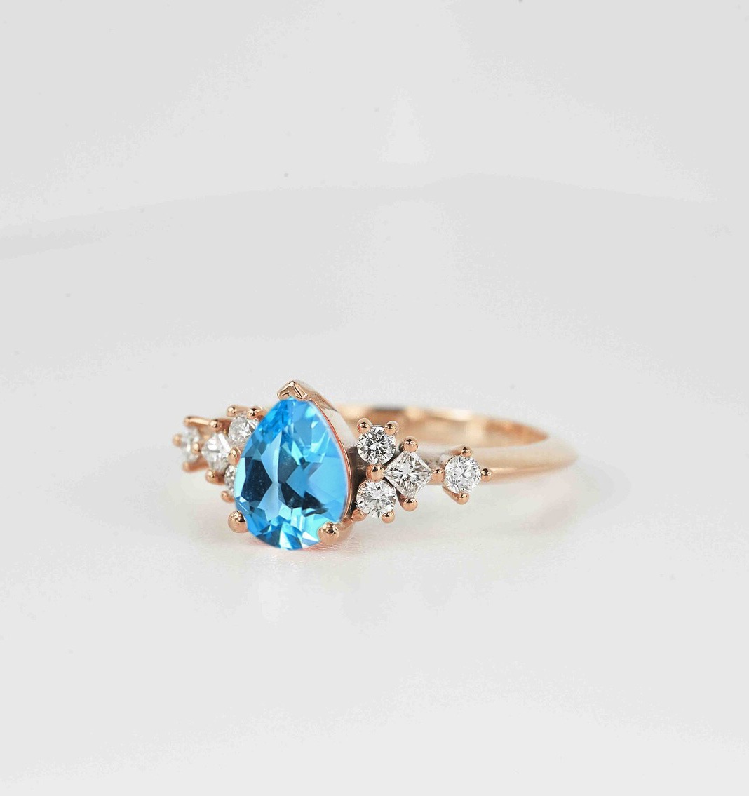 This beautiful pear cut blue topaz bridal ring comes with a center 1.50ct blue topaz and white natural diamonds. Available in rose gold, yellow gold, white gold, or platinum.