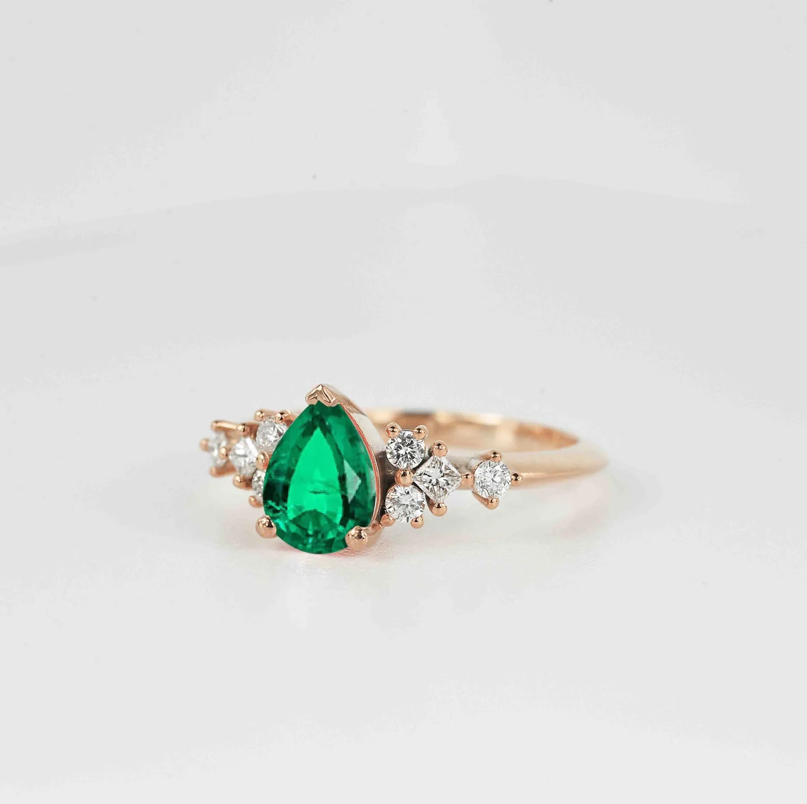 emerald and diamond cluster gift ring with pear shape emerald and round and princess cut accent diamonds.