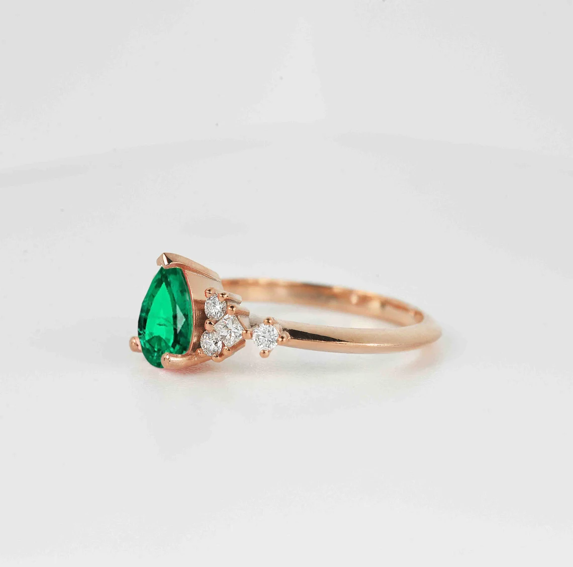 emerald and diamond cluster gift ring with pear shape emerald and round and princess cut accent diamonds.