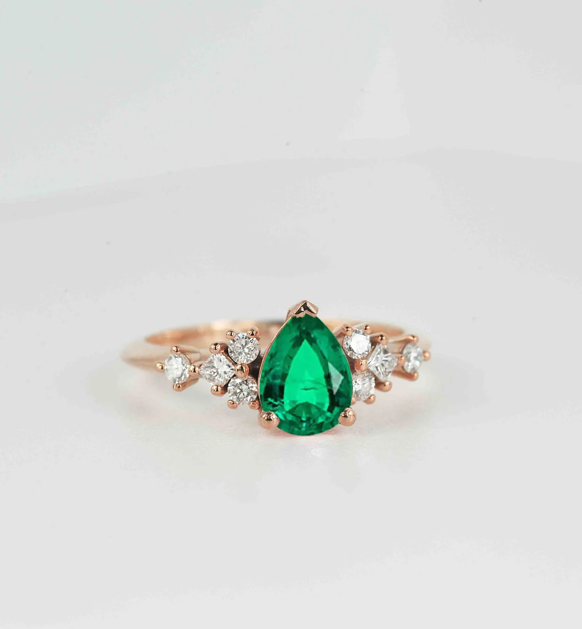 emerald and diamond cluster gift ring with pear shape emerald and round and princess cut accent diamonds.