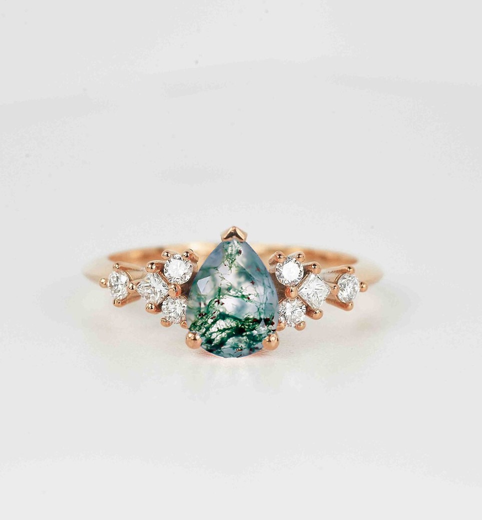 This beautiful pear cut moss agate and diamond anniversary ring comes with a center 1.50ct moss agate and white natural diamonds. Available in rose gold, yellow gold, white gold, or platinum.