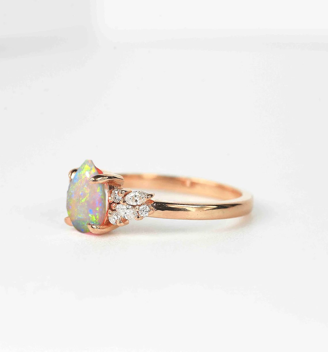 Opal and diamond cluster anniversary ring with 8 x 6mm opal and white accent diamonds. The unique design of this art deco style ring comes with solid 9k,14k or 18k gold or platinum.