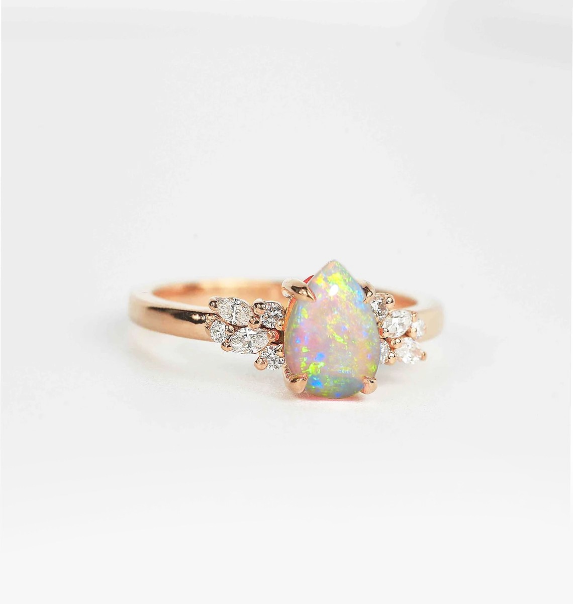Opal and diamond cluster anniversary ring with 8 x 6mm opal and white accent diamonds. The unique design of this art deco style ring comes with solid 9k,14k or 18k gold or platinum.