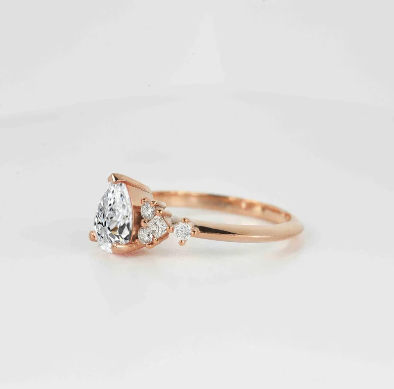 This beautiful pear cut diamond unique ring comes with a center 1.50ct lab grown diamond and white natural diamonds. Available in rose gold, yellow gold, white gold, or platinum.